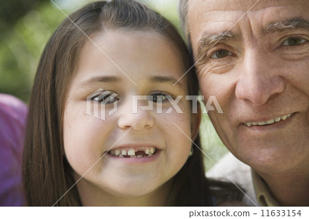 Close up of grandfather and young granddaughter smiling 11633154