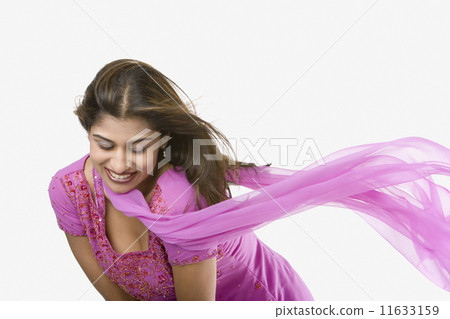 Woman bending over with scarf blowing in breeze 11633159