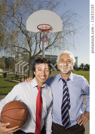 Two Hispanic businessmen on a basketball court  11633193