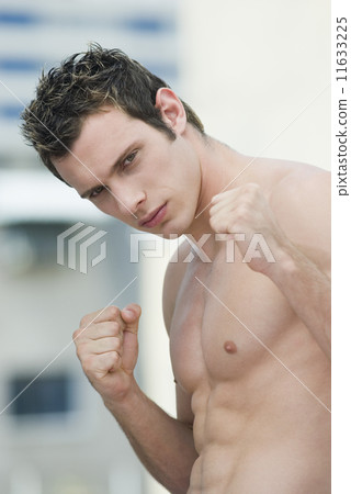 Bare-chested man in fighting stance 11633225