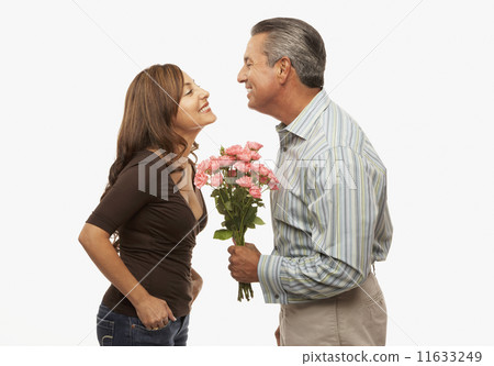 Hispanic man giving flowers to wife Hispanic man giving flowers to wife 11633249