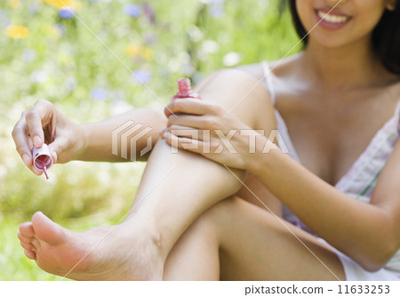 Lower section of woman painting toenails 11633253