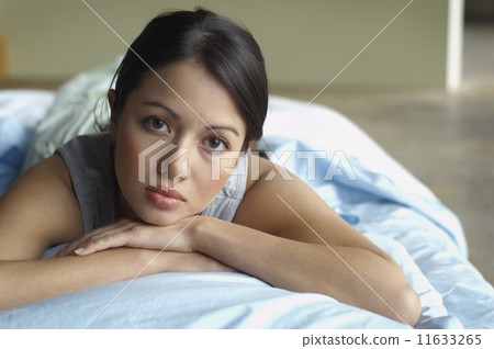 Portrait of Hispanic woman laying bed 11633265