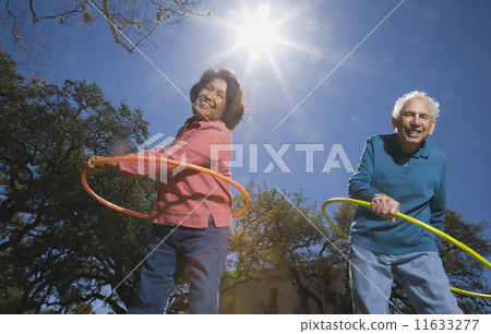 Low angle view of senior couple with plastic hoops Low angle view of senior couple with plastic hoops 11633277