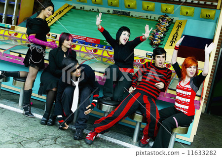 Group of punk Hispanic teenagers cheering in carnival booth 11633282