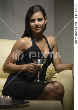 Woman in evening gown holding cocktail Woman in evening gown holding cocktail 11633303