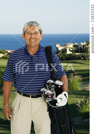 Hispanic man holding bag of golf clubs Hispanic man holding bag of golf clubs 11633332