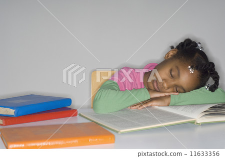 African girl sleeping on open book 11633356