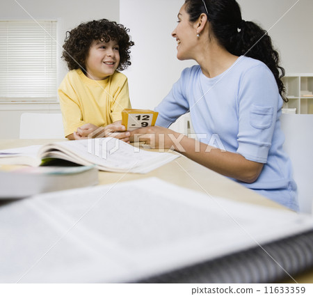 Hispanic mother helping son with homework 11633359