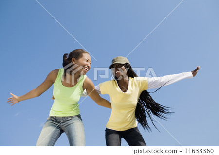 African women with arms outstretched 11633360