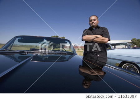 Hispanic man next to show car 11633397