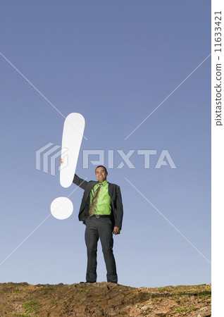 Asian businessman holding exclamation point Asian businessman holding exclamation point 11633421
