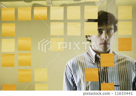 Businessman standing behind decorative glass 11633441