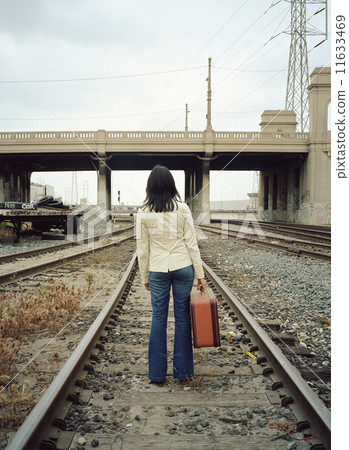 Young woman walking on train tracks 11633469