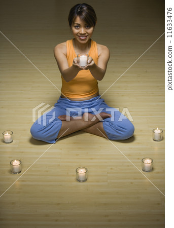 Pacific Islander woman holding lit candle 11633476