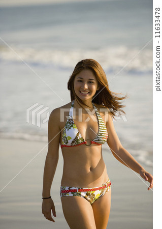 Asian girl walking on beach 11633478