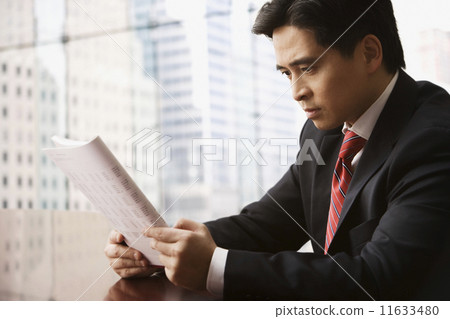 Chinese businessman reading report Chinese businessman reading report 11633480