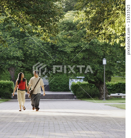 Couple walking outside holding hands 11633525