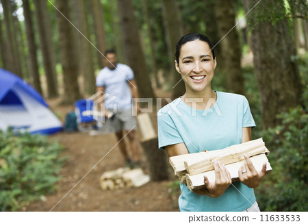 Hispanic woman carrying chopped wood 11633533