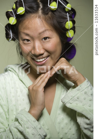 Asian woman with curlers in hair Asian woman with curlers in hair 11633534