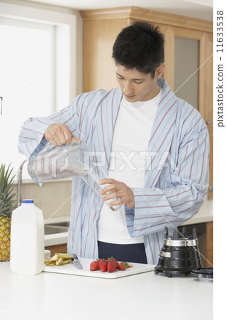 Asian man making fruit smoothie Asian man making fruit smoothie 11633538