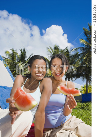 Hispanic women eating watermelon Hispanic women eating watermelon 11633558