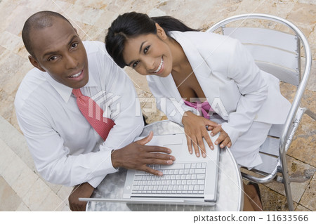 Hispanic couple with laptop at cafe Hispanic couple with laptop at cafe 11633566