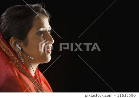 Indian woman wearing hands free device 11633590