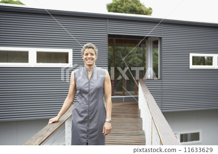 Mixed Race woman standing in front of house 11633629