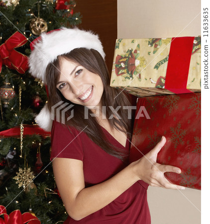 Hispanic woman holding Christmas gifts Hispanic woman holding Christmas gifts 11633635