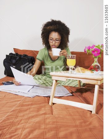 African woman eating breakfast in bed African woman eating breakfast in bed 11633685