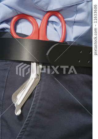 Close up of surgical scissors in person's belt 11633686