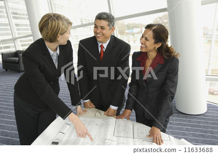 Multi-ethnic businesspeople discussing blueprints Multi-ethnic businesspeople discussing blueprints 11633688