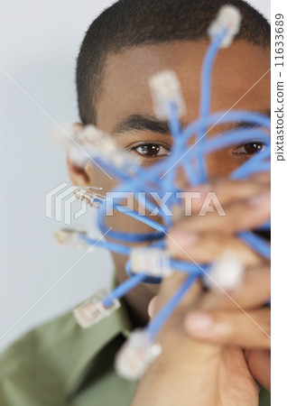 Young man holding Ethernet cables 11633689