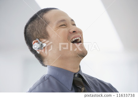 Asian businessman talking on hands-free device 11633738
