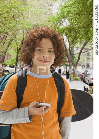 Mixed Race boy listening to mp3 player 11633760