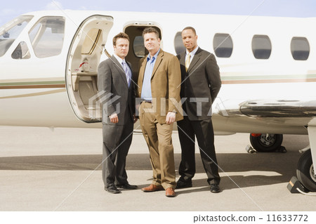 Multi-ethnic businessmen in front of airplane 11633772