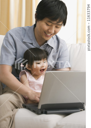 Asian father and baby daughter looking at laptop 11633794