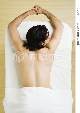 Asian man laying on massage table Asian man laying on massage table 11633820