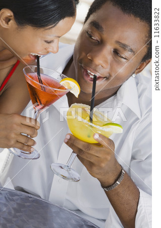 Multi-ethnic couple drinking cocktails Multi-ethnic couple drinking cocktails 11633822