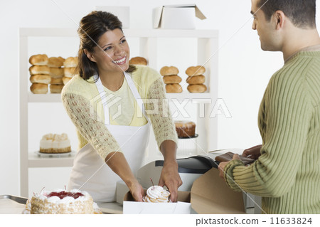 Woman at bakery helping customer 11633824