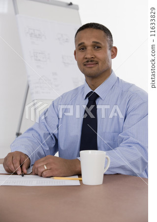 African businessman at table with paperwork African businessman at table with paperwork 11633829