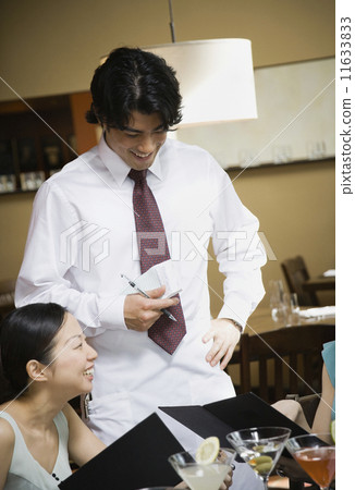 Asian male server taking order Asian male server taking order 11633833