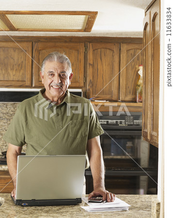 Senior Hispanic man paying bills 11633834