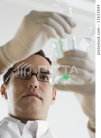 Scientist examining chemicals in test tubes Scientist examining chemicals in test tubes 11633844