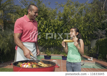 Hispanic father and daughter barbequing 11633845