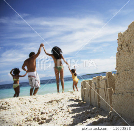 Hispanic family with sand castle in foreground 11633858