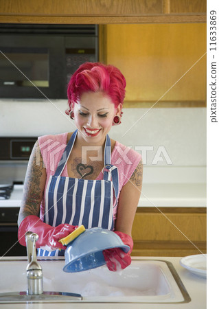 Tattooed Hispanic woman washing dishes Tattooed Hispanic woman washing dishes 11633869