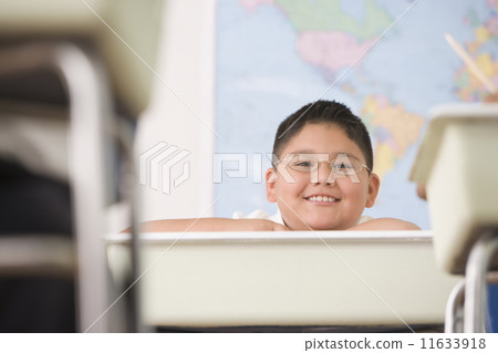 Hispanic boy sitting at school desk 11633918