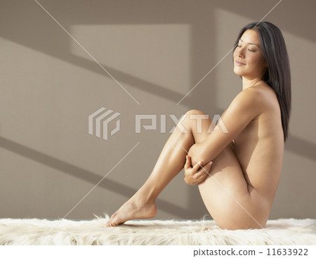 Nude Asian woman pulling knees up to chest 11633922